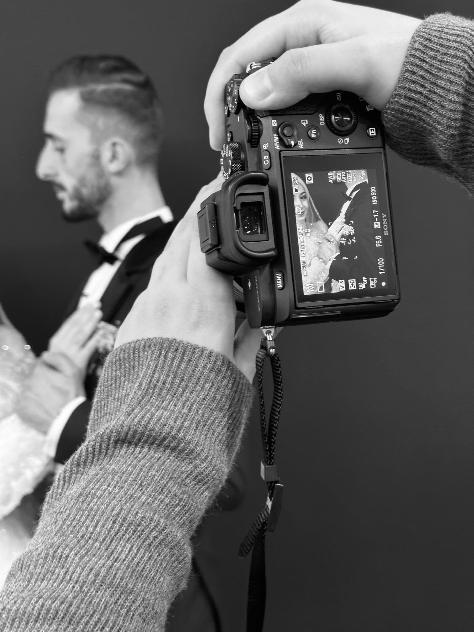 Photographe de mariage en action photographiant les mariés pendant la cérémonie