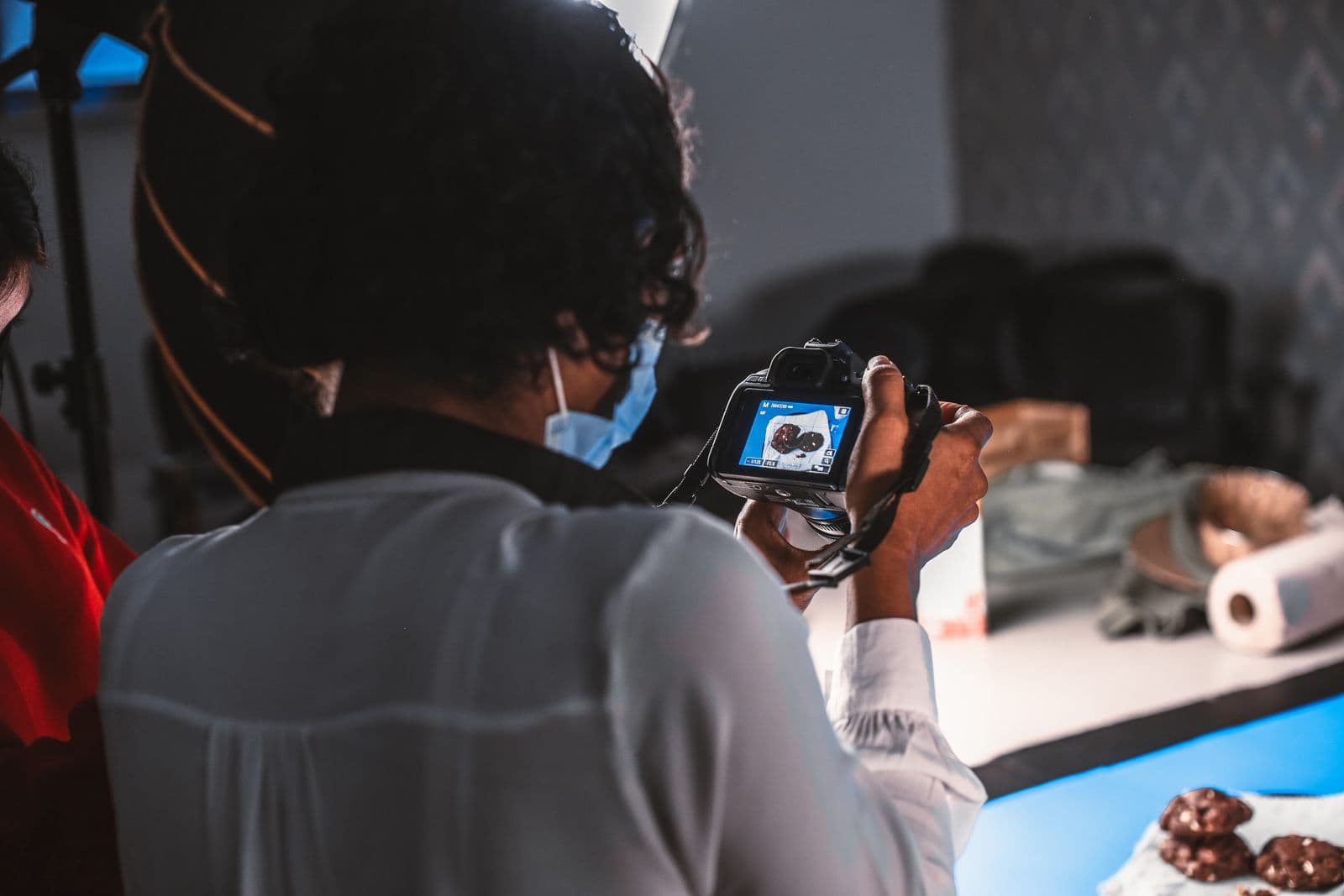 Photographe cadrant un produit en studio sur une table de prise de vue éclairée